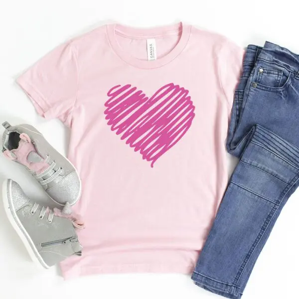 Pink t-shirt with darker pink scribble heart, gray sneakers, and blue jeans.