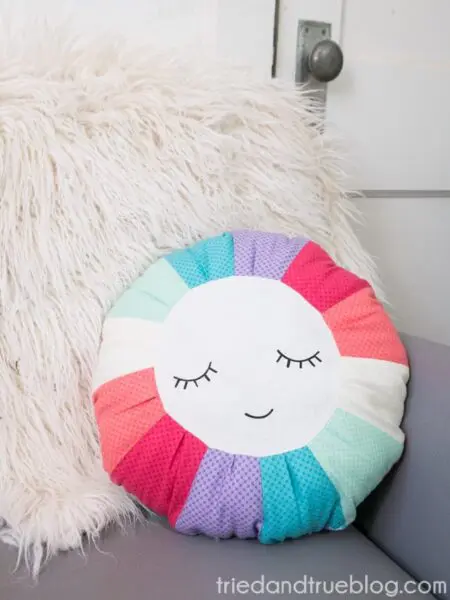 Free download of round white pillow with closed eyes and mouth and multi-colored outside edges.
