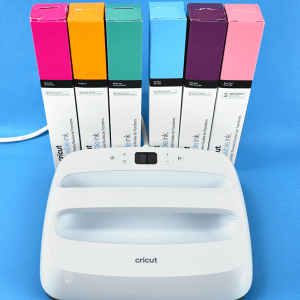 Cricut Easypress on a blue background with colorful Infusible Ink behind the press.