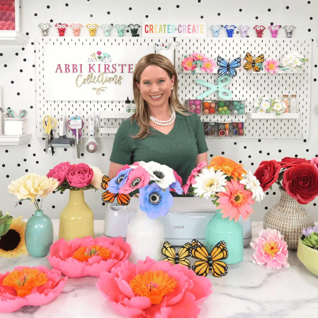 Abbi Kirsten in front of handmade crepe paper flowers