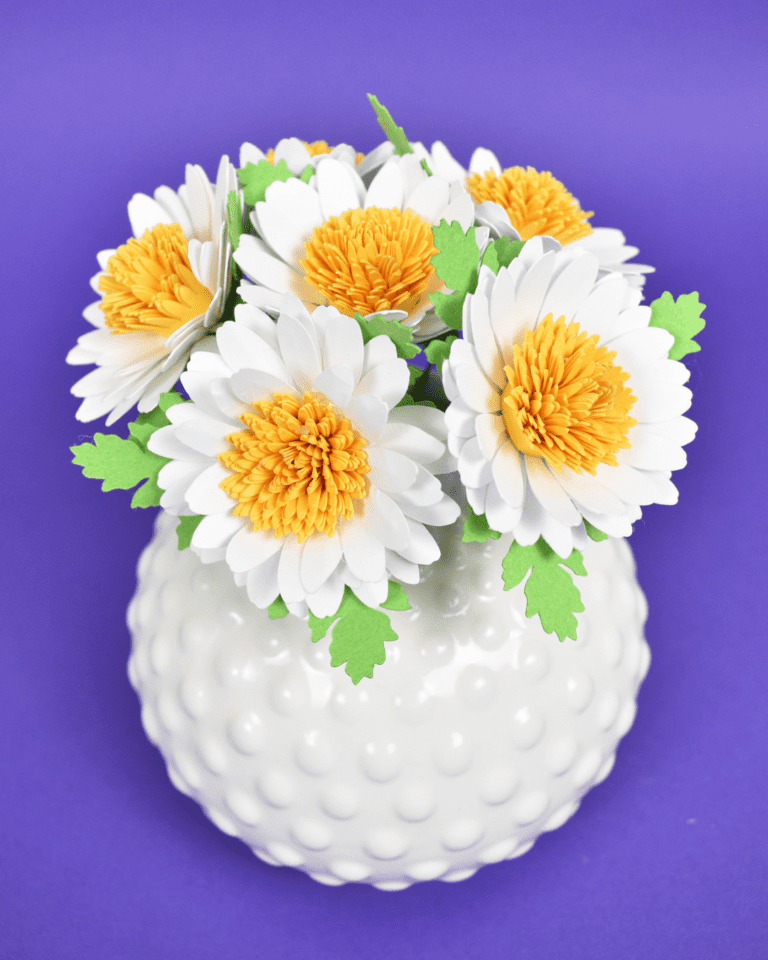 bouquet of white small daisies with yellow centers in white vase