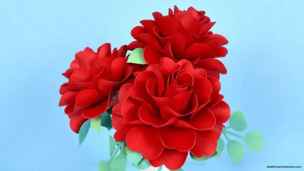 bouquet of 3 red classic roses with leaves in white vase