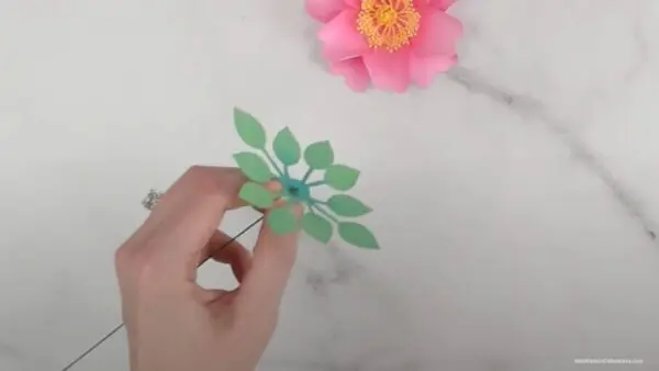 threading wire stem through punched hole of leaf center