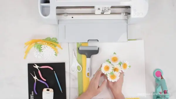 Cricut machine and craft supplies for making daisies