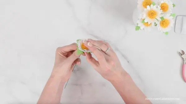 gluing the mini daisy flower to the base