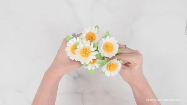 hands holding mini daisies bouquet