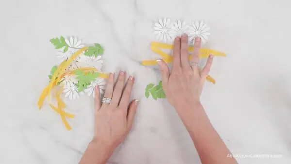 white daisy petals and yellow center strips with greenery