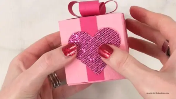 glitter heart being glued to front of handmade paper box
