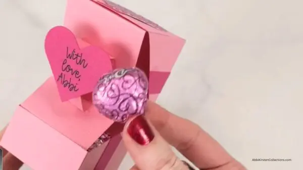 holding chocolate candy from inside the gift box