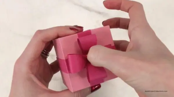 pressing bow loops to glue to center of ribboned box