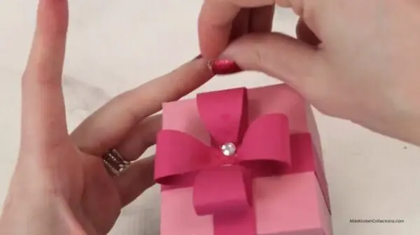 adding rhinestone embellishments to center of bow