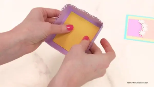 Gluing yellow square to inside of gift box