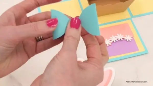 Folding pastel blue bunny bow inward