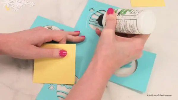 Gluing yellow pieces to inside of blue box