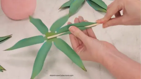 curling the paper agave leaf around a wood dowel