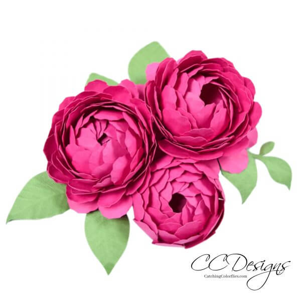 A trio of bright pink paper peonies with green paper leaves. 