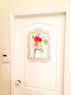 This wood and paper craft wall art decor hangs nicely on the door of this home. 