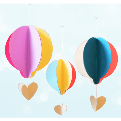 Colorful paper hot air balloons hang from strings