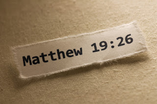 A small square of paper with the words "Matthew 19:26", a Bible verse.