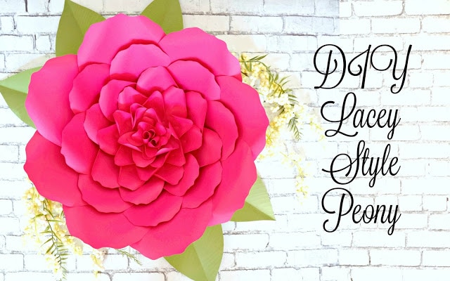 A large paper peony, complete with paper greenery is seen above a white brick wall. The text reads, "DIY Lacey Style Peony." 