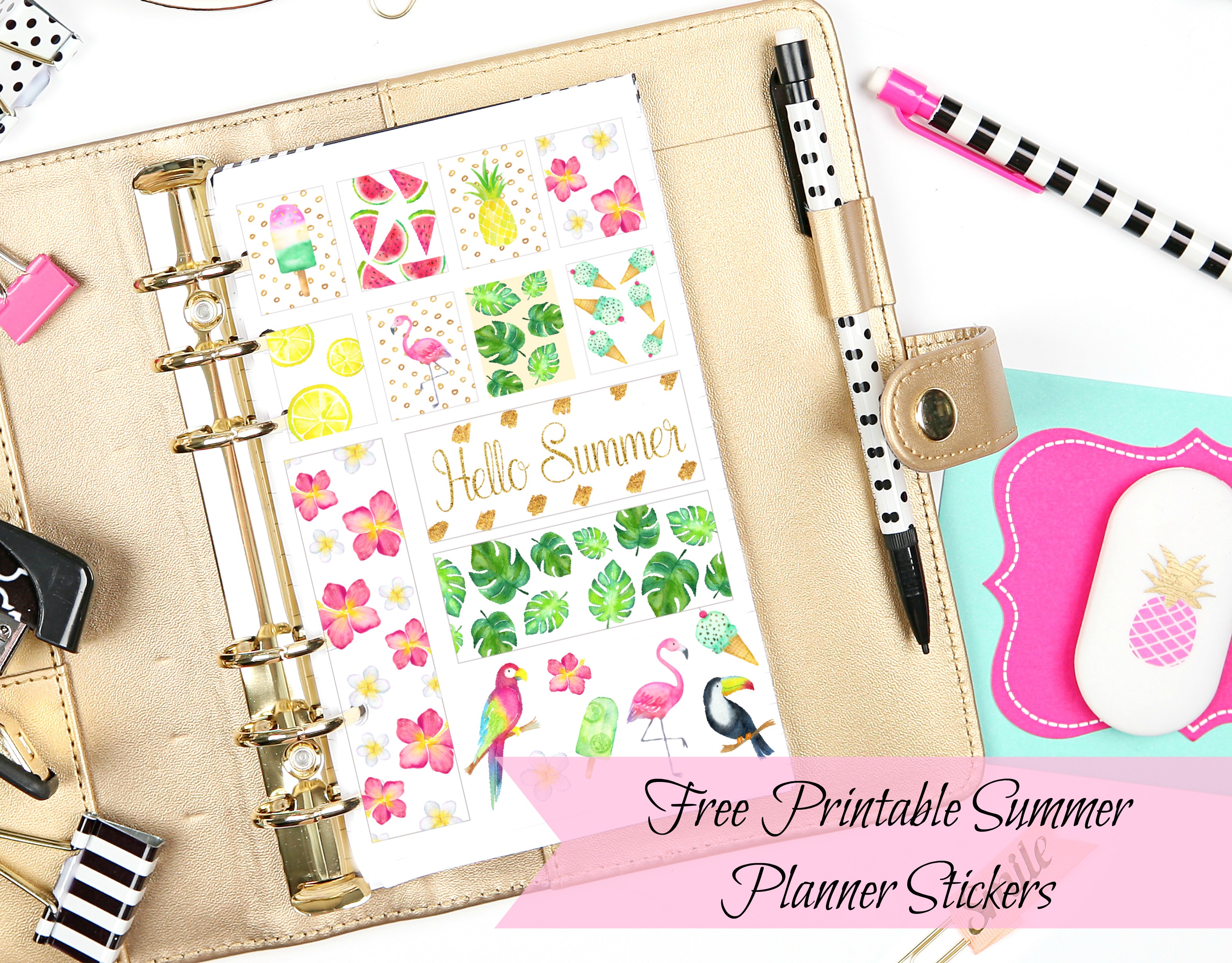 An open planner has a brightly colored tropical sticker page full of pineapples, parrots, flamingos, flowers, and more. Binder clips, colored paper, and pencils are nearby. The text reads, "Free Printable Summer Planner Stickers."