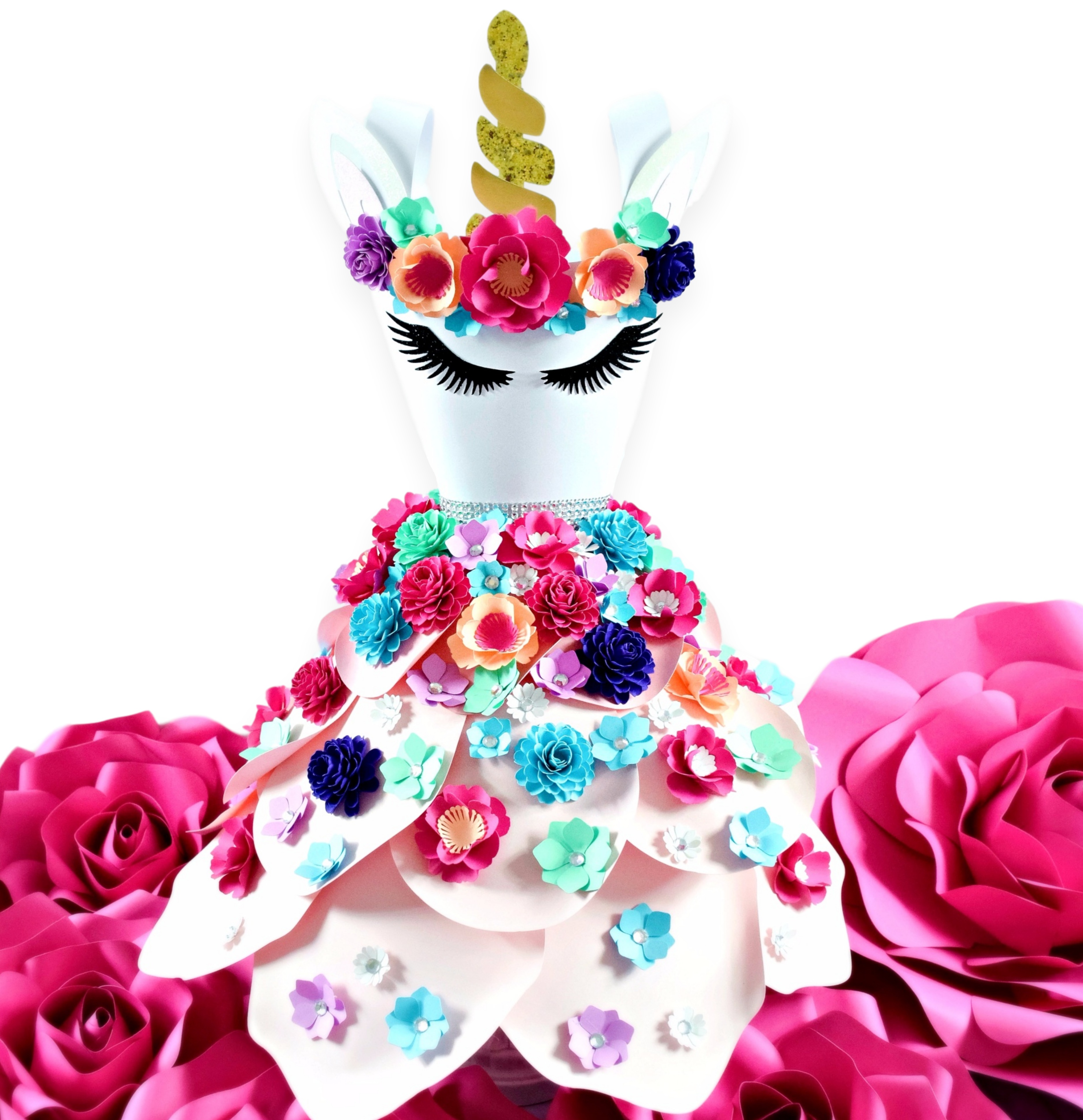 A paper dress decorated to look like a unicorn, with many colorful flowers flowing down the paper skirt, and a unicorn face on the bodice of the paper dress.