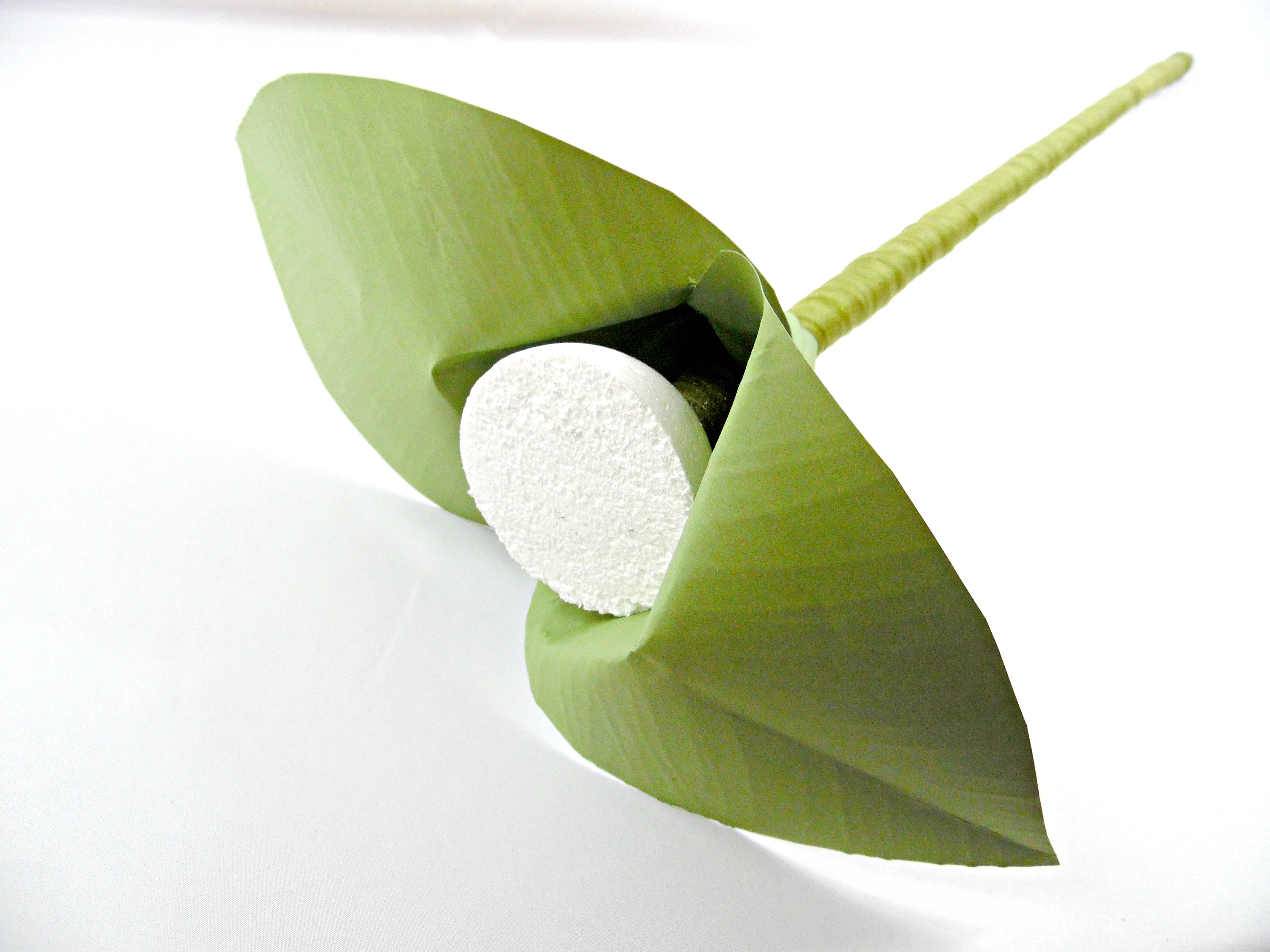 Two giant green paper flower leaves are attached to the giant paper flower stem. These paper leaves add extra support to the foam ball, the center of the giant paper flower.  
