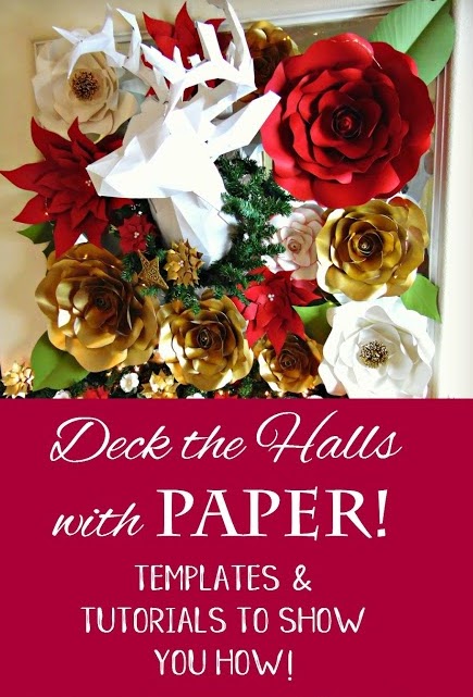 Red, white, and gold Christmas-themed paper flower garland with lights hangs on a white wall.