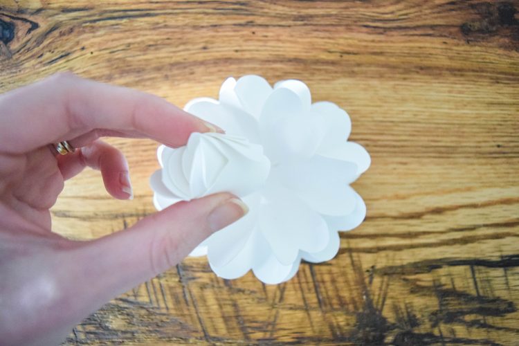 Abbi places the center of the white pomander paper flower.