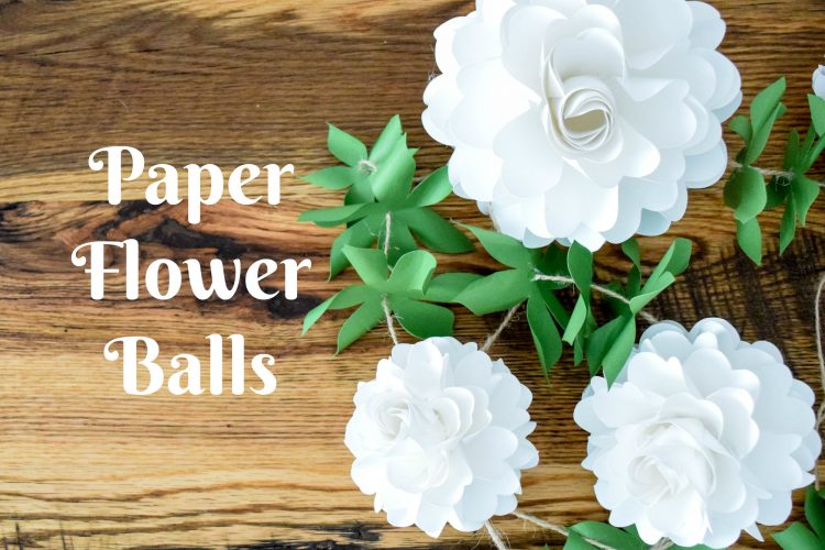 Three white pomander paper flower balls, attached to twine with green paper leaves. White image text reads "paper flower balls"