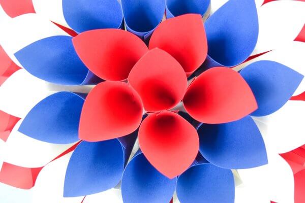 The final layer of cones is six red cones in the center of the paper dahlia wreath. It's surrounded by a blue layer, white layer, and red layer moving outwards.