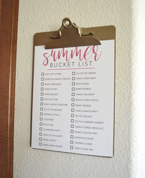 A gold clipboard hangs on a wall near a door. On the clipboard is a checklist with the title, "summer bucket list."