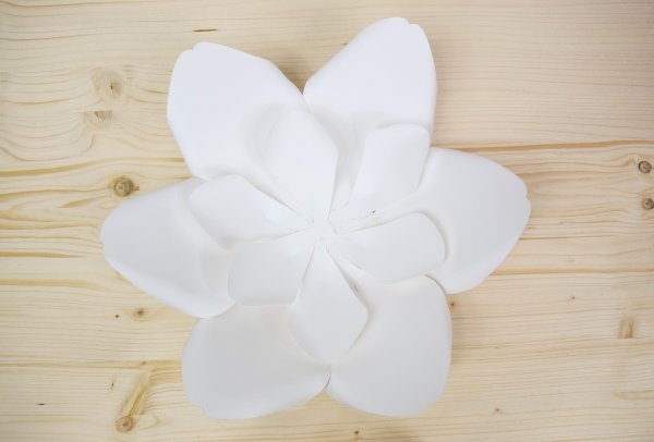 A smaller second layer of white paper petals attached to a larger first layer of white paper petals. 