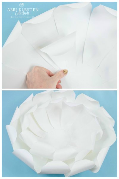 The upper image has Abbi Kirsten's hand holding down one petal from the second layer of the giant white peony paper flower. Below, and overhead view of the second layer of this enormous flower. 
