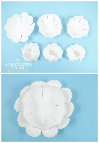 Stacks of white paper petals sit on blue paper. Some of the petals are curled and cupped inwards, and other are more open. The second image shows how to stack the petals to create a giant DIY snowy paper peony flower. 