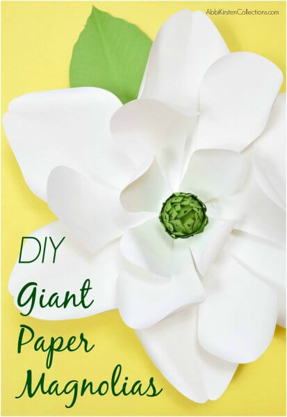 A Giant White Paper Magnolia with green leaves and stamen set against a yellow background.