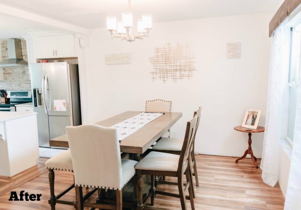 A fancy dining room decorated in whites and creams next to an open-concept kitchen. The dining-room table has chairs and an upholstered bench. 