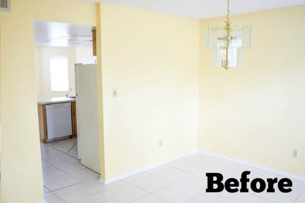 An empty dining room with light yellow walls and a large vinyl tile floor is ready to be renovated and refreshed. "Before" is in text in the corner. 