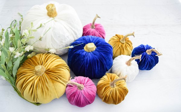 A gorgeous display of no-sew velvet pumpkin in different sizes and velvet fabric colors - gold, pink, white, and blue pumpkins.