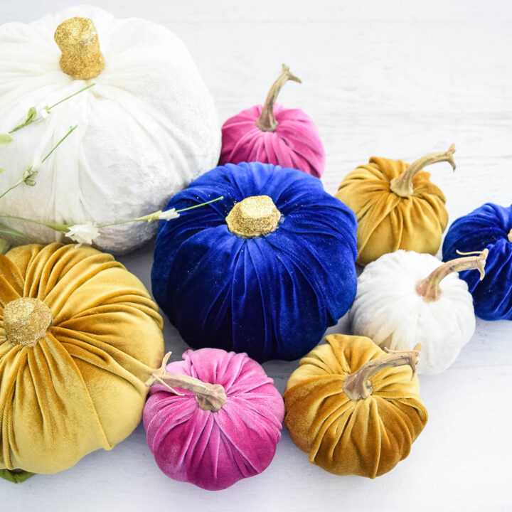 A collection of no-sew velvet pumpkins in different sizes, covered in white, blue, gold, and pink velvet.
