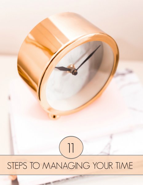 The top and face of a gold round analog alarm clock on white marble. The text below reads, "11 steps to managing your time."