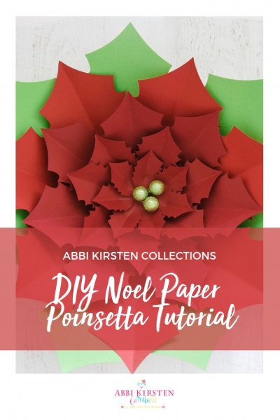 A large red and green Noel Poinsettia flower with green holly berries in the middle. Image text overlay reads "DIY Noel Paper Poinsettia Tutorial"