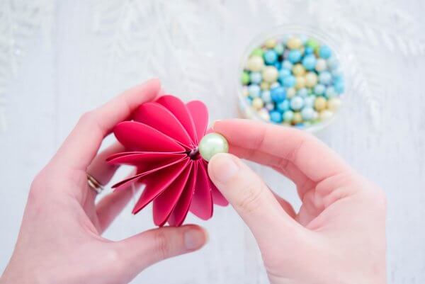 Abbi Kirsten adds a light green craft pearl to the bottom of the pink 3D paper ornament for extra flair. 