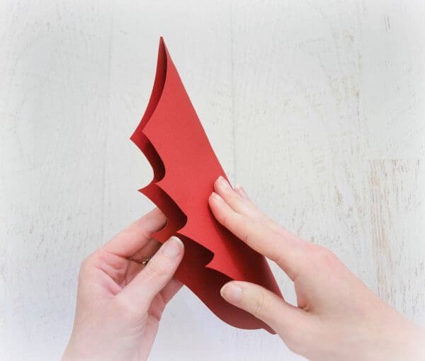 Abbi demonstrates how to fold the large red poinsettia flower petals.