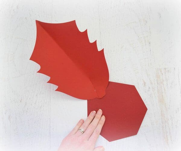 A large hexagonal paper base with one large poinsettia leaf glued to one of the sides. This will act as the base of the large Noel Poinsettia flower.