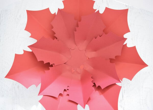 A second layer of slightly smaller red poinsettia flower petals has been added to the base, creating a fuller flower.