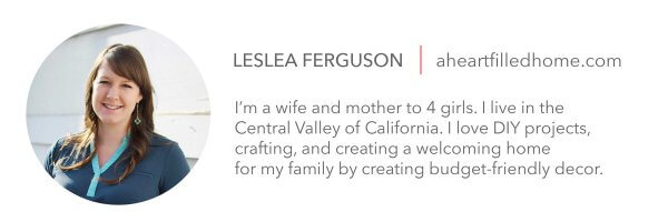 A picture of Leslea Ferguson in a round cutout. On the right is her information which reads "Leslea Fergusom, Aheartfilledhome.com, I'm a wife and mother to 4 girls. I live in the Central Valley of California. I love DIY projects, crafting, and creating a welcoming home for my family by creating budget-friendly decor."