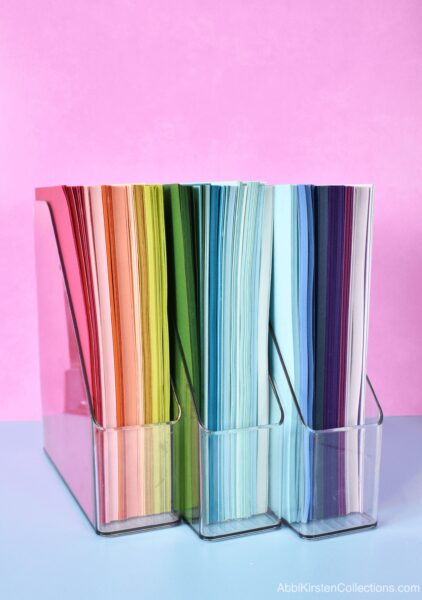 Clear magazine holders for craft paper storage and organization.