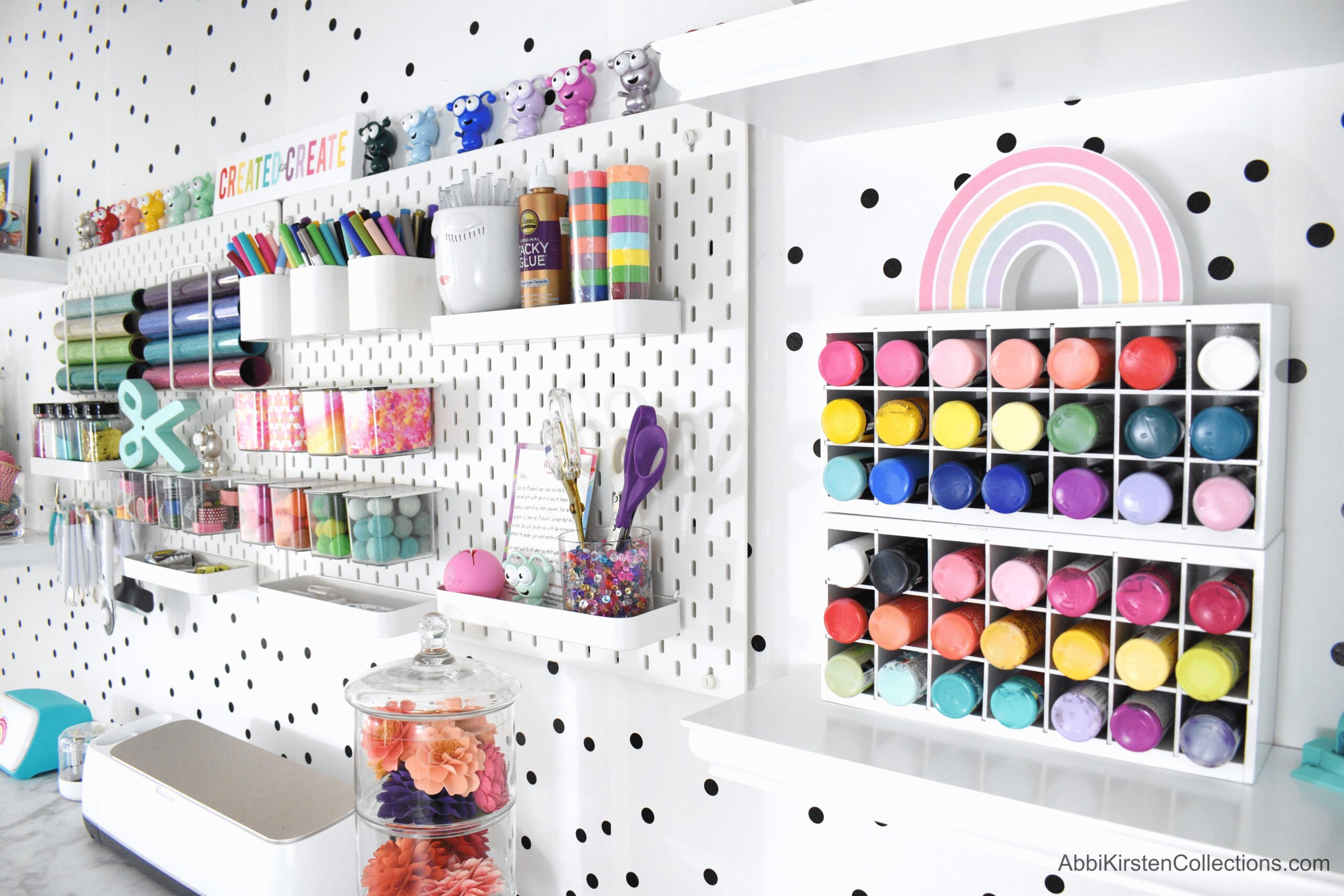 A polka-dot accented wall has more wall organizers to hold multiple craft supplies.