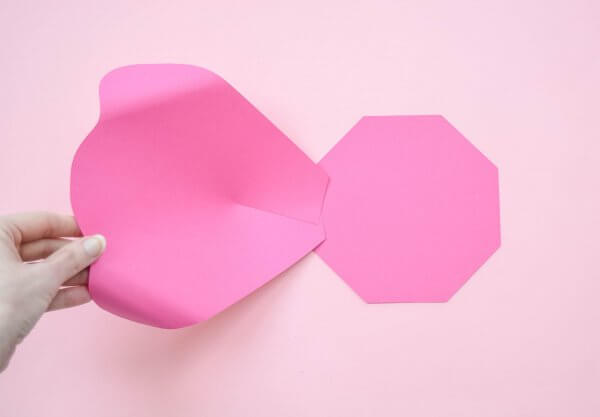 The finished extra-large pink paper petal is glued to the eight-sided base, to form the bottom layer of the Penelope paper roses. 